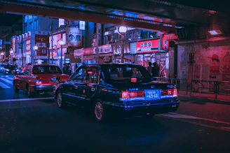 A vibrant street scene with diverse cars from Japan, America, and Europe under colorful city lights.