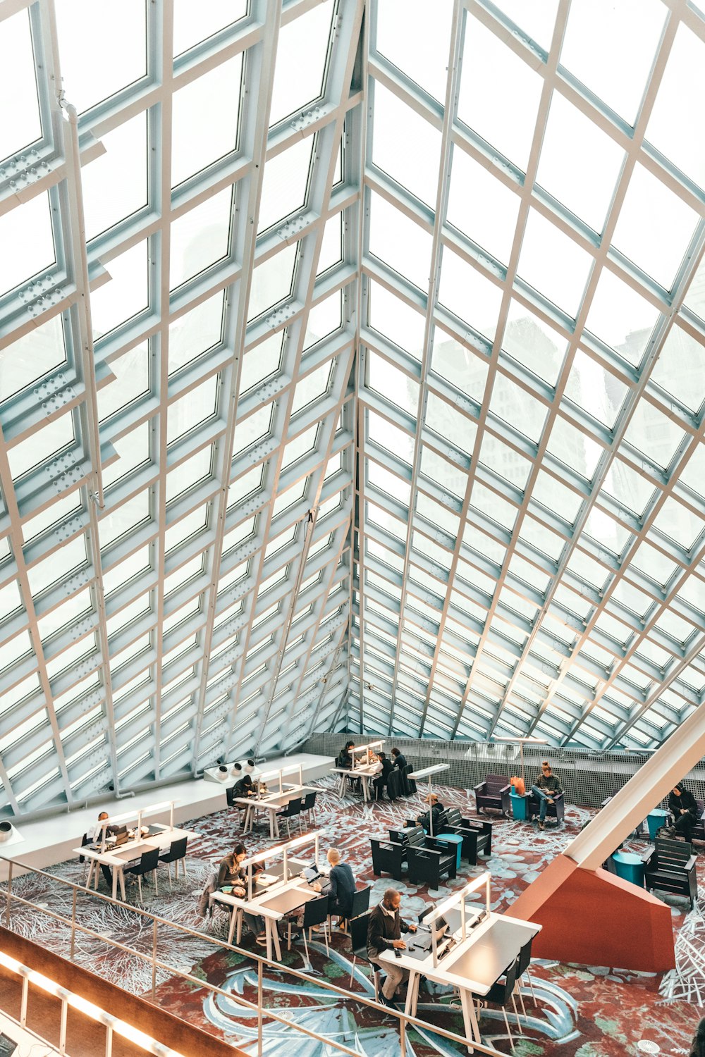 people by tables inside glass roofed building