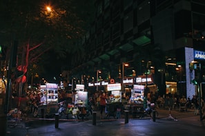 Nighttime street scene with illuminated food cart and customers in Barcelona