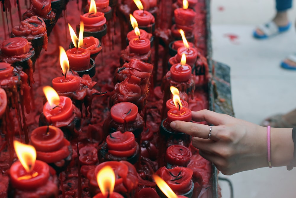 persona sosteniendo una vela roja