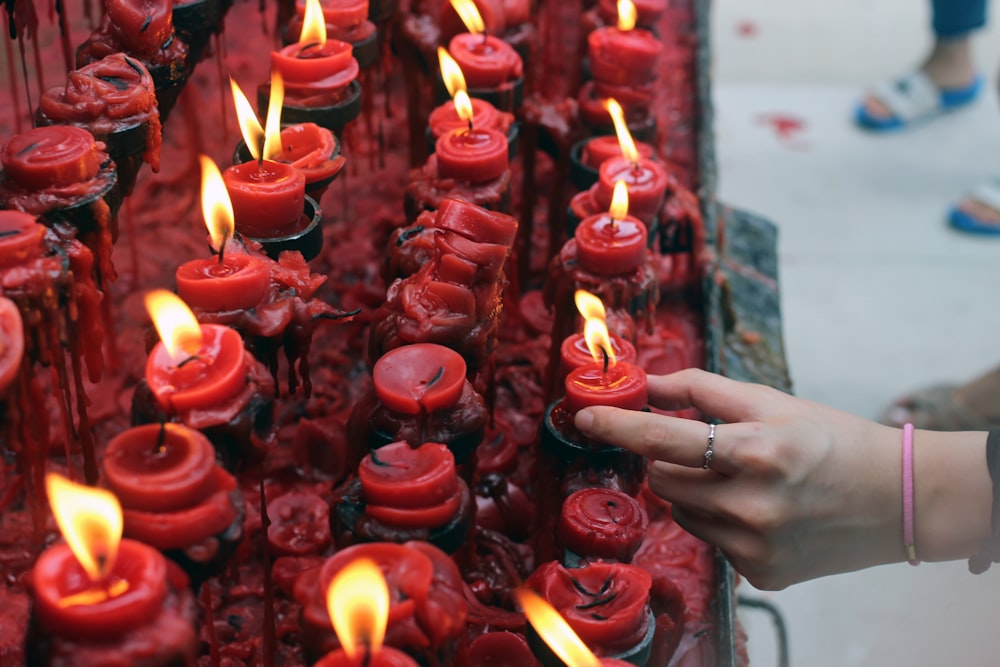 person holding red candle