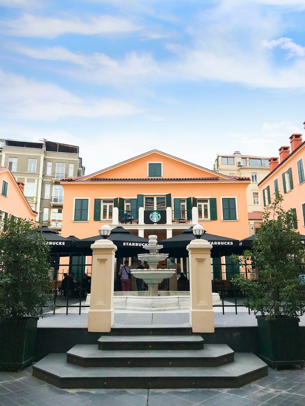 white outdoor fountain across black canopy tents