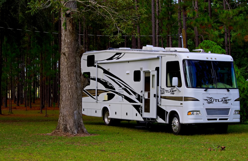 Outlaw RV parked on grass near trees