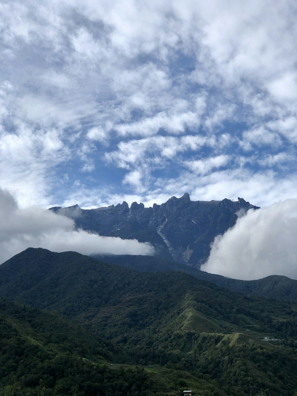 green mountain under white clouds