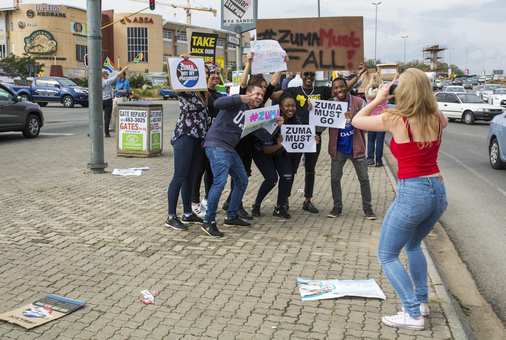 woman taking picture of people during daytime