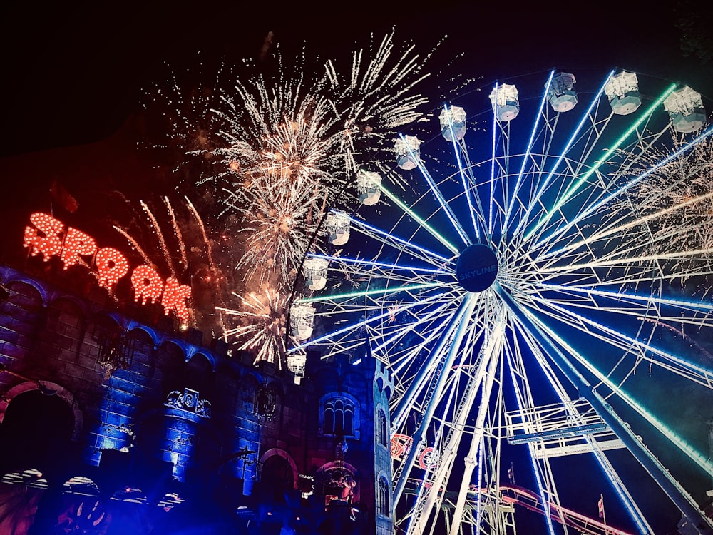 lighted ferris wheel and fireworks during nighttime