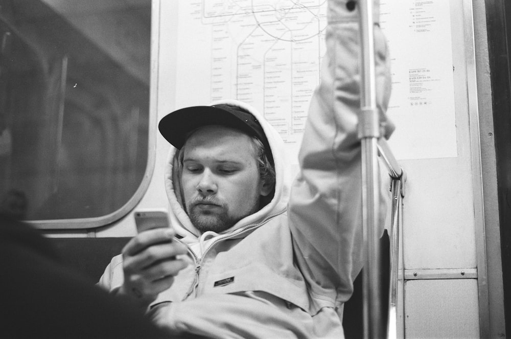 grayscale photography of man siting inside train