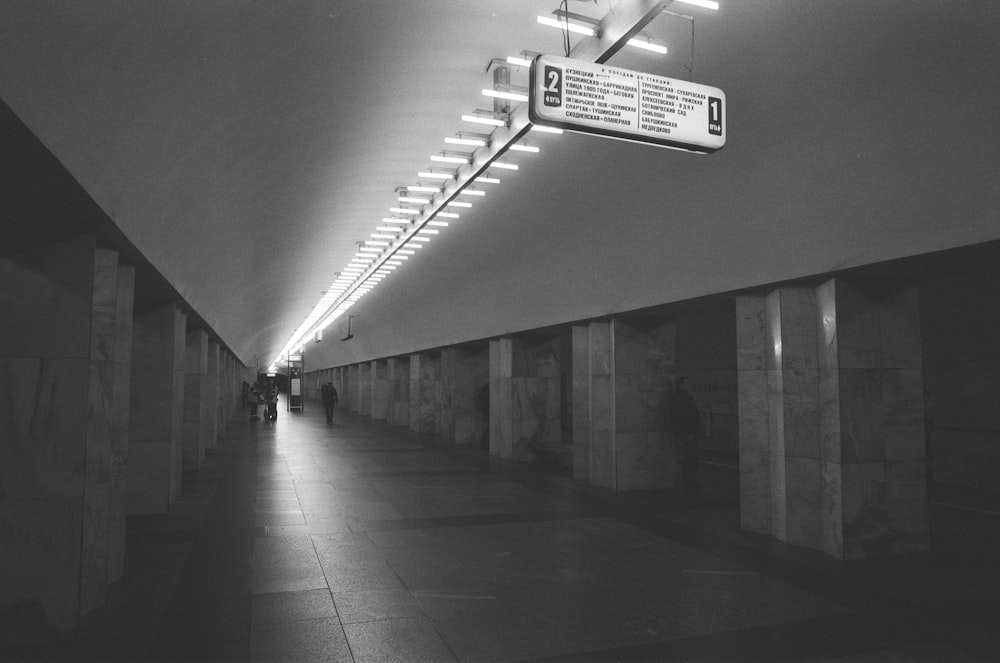 people walking in the station grayscale photo