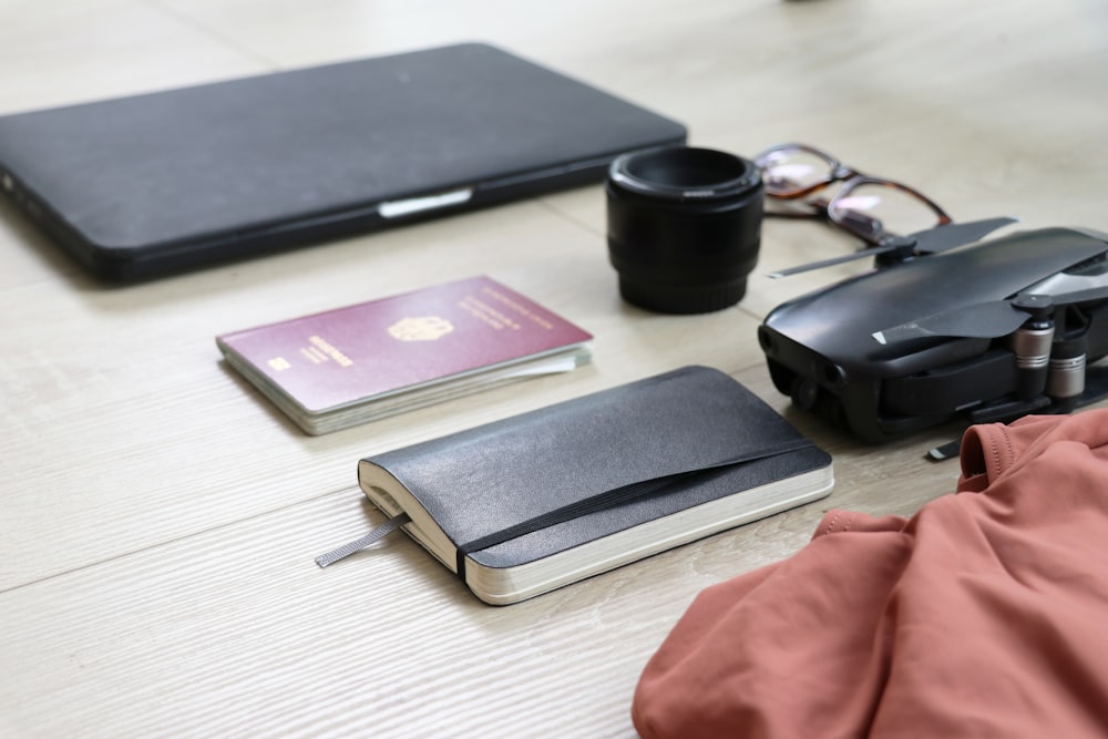 books, camera lens, and drone on wooden surface