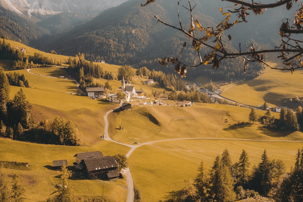 aerial photography of houses on green field viewing mountain during daytime