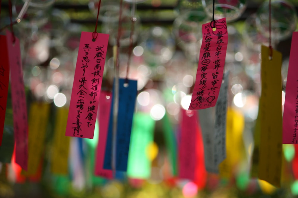 a group of colorful paper notes hanging from strings