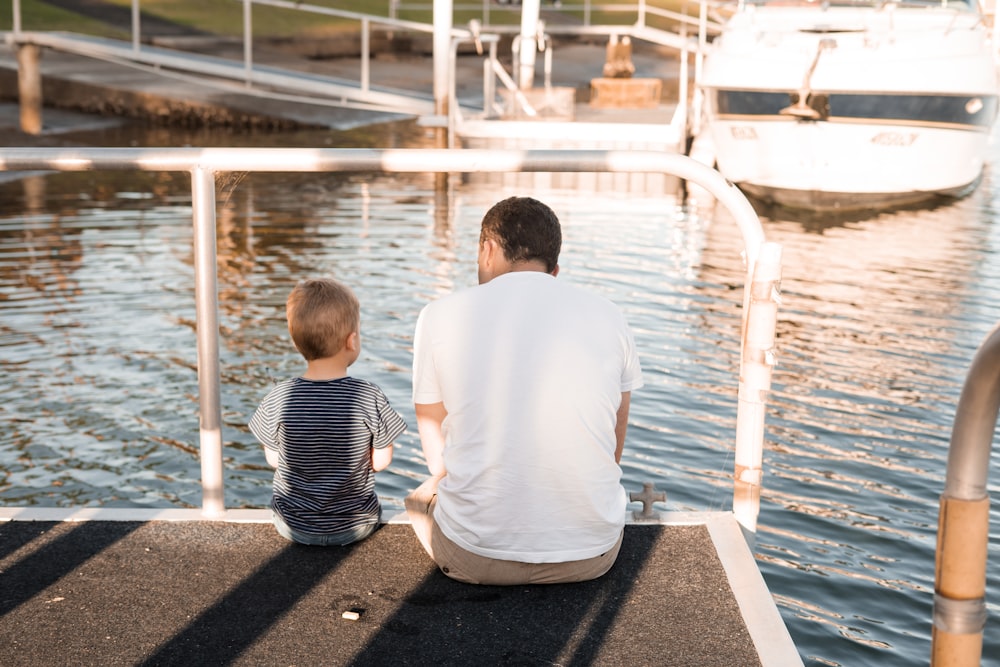 man and boy sitting on dock