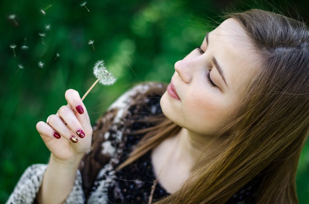 woman blowing dandelion