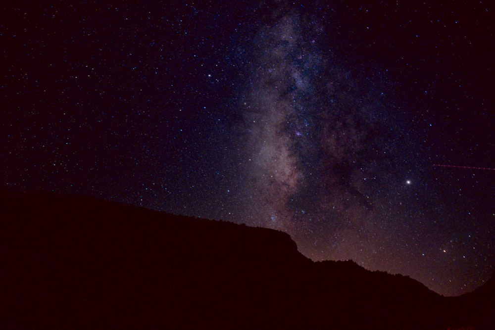 silhouette of mountain during night time