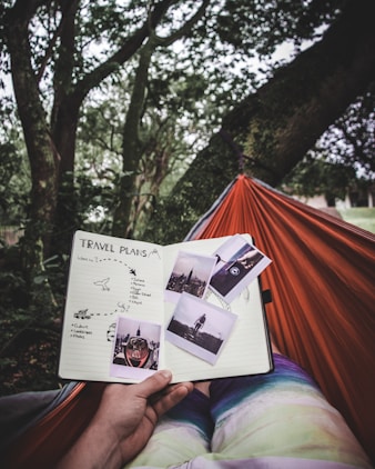 person in the hammock looking on travel plans