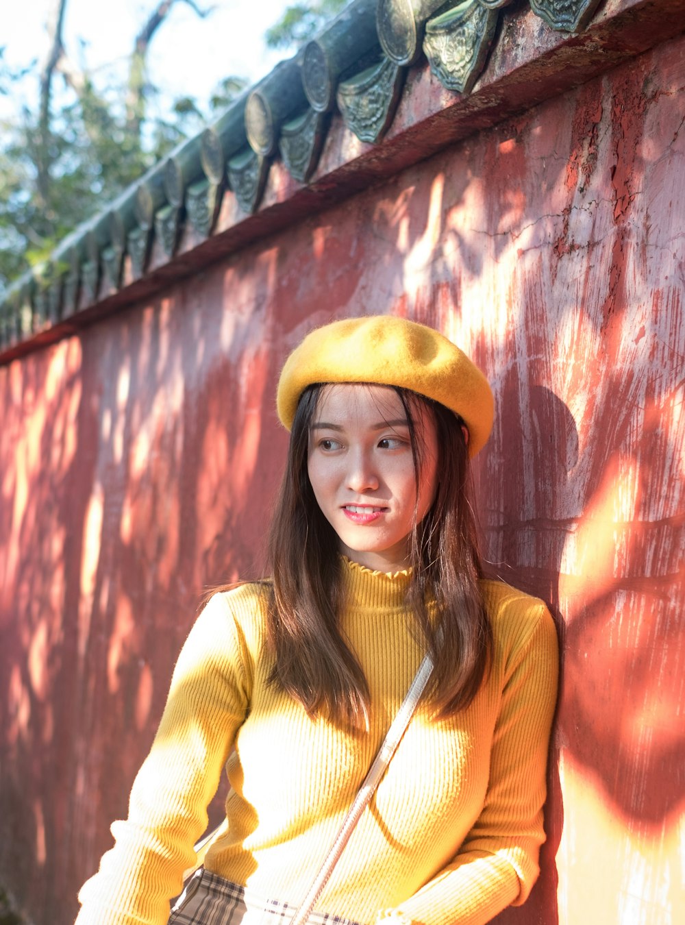 woman leaning on brown concrete wall