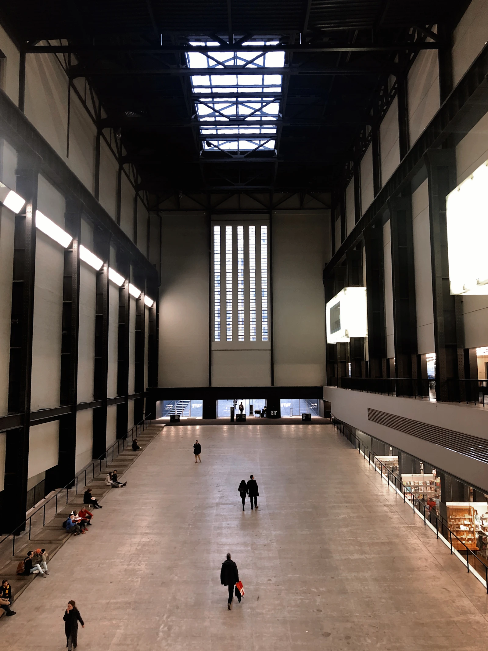 Travel photograph: Small groups of visitors crossing the vast floor of Tate Modern's Turbine Hall.