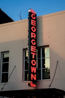 Exterior shot of 1254 Wisconsin Ave NW with the Georgetown Remedy House sign visible on a sunny day.