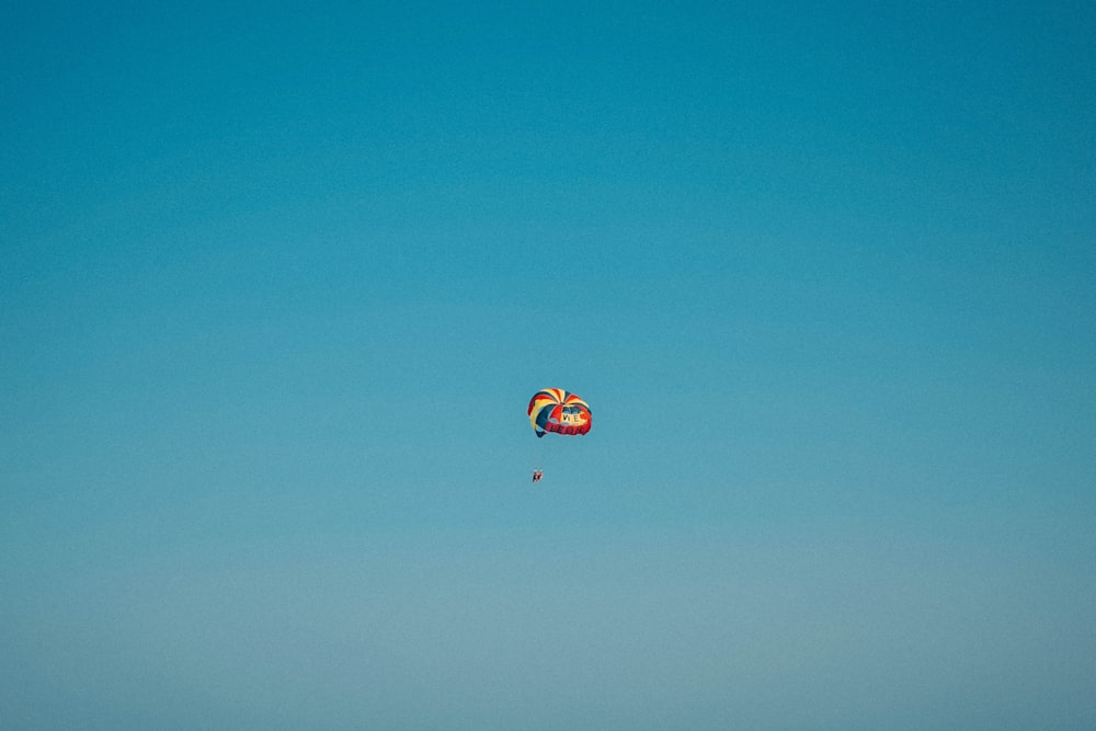 昼間の空に浮かぶ色とりどりのパラシュート