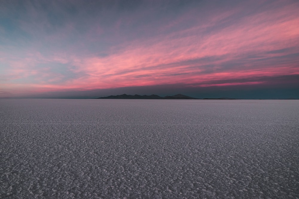 the sky is pink and blue as the sun sets