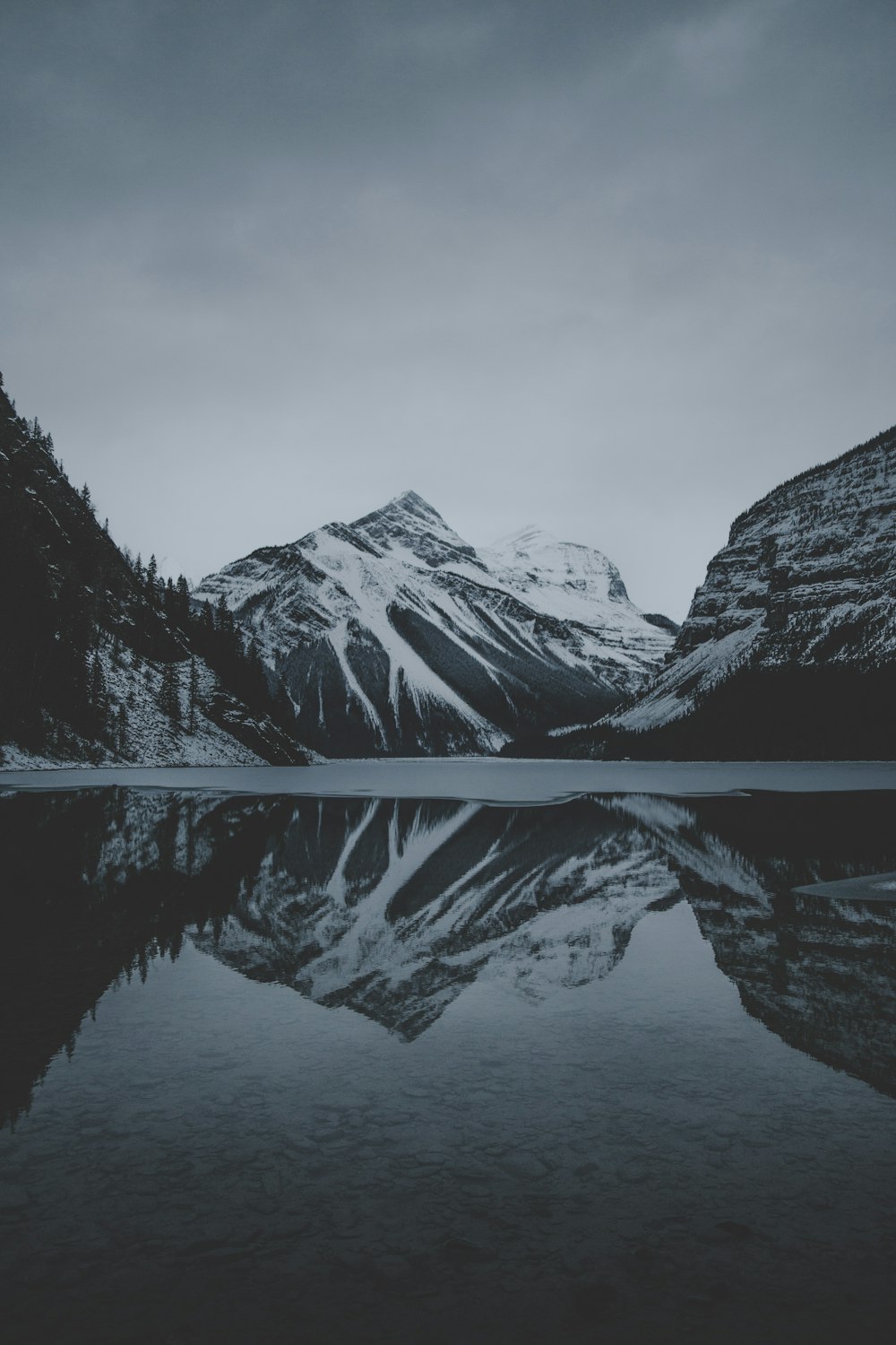 snow mountains and lake undr gray sky