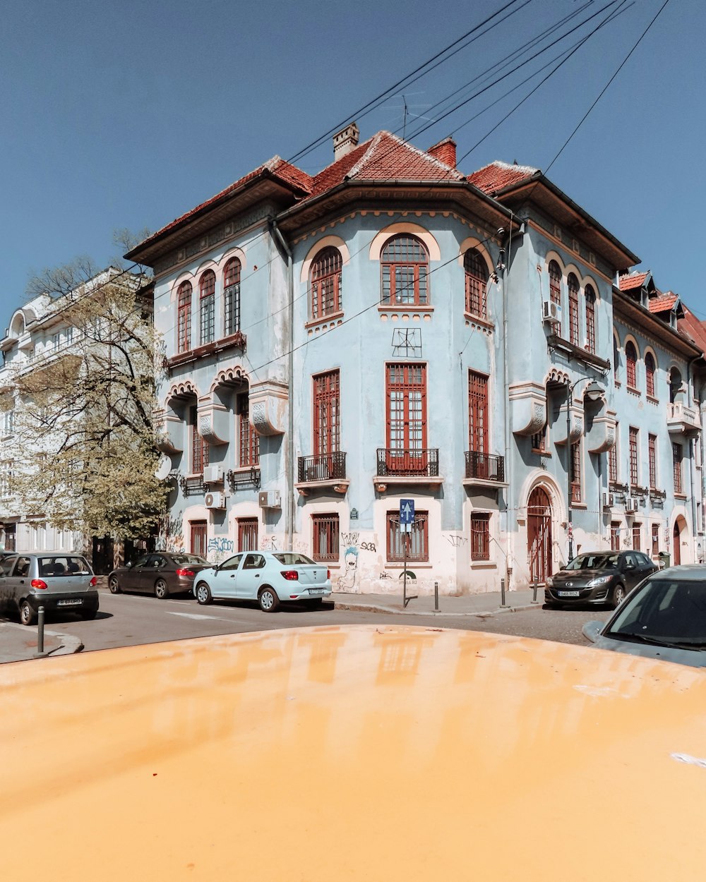 vehicle passing teal building near the corner street