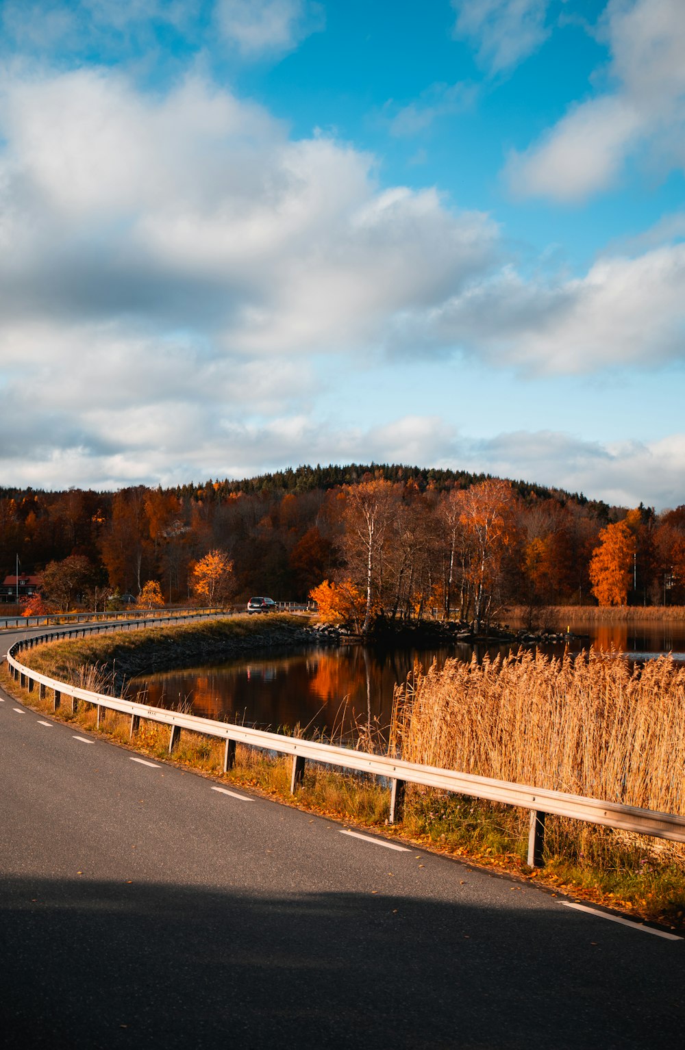 road viewing mountain under white and blue sky during daytime