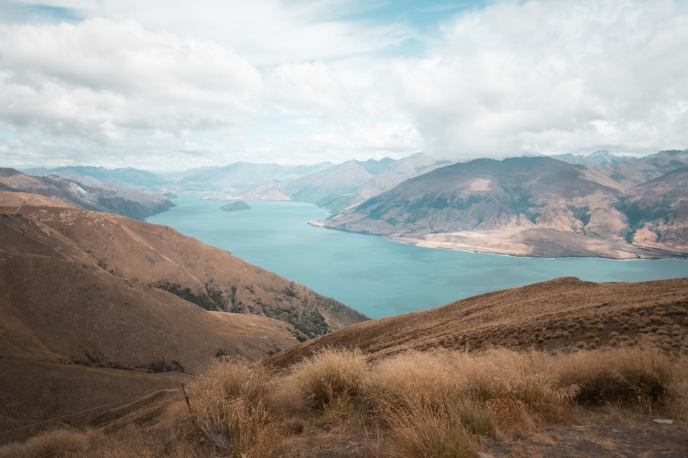 mountains near body of water under cloudy sky