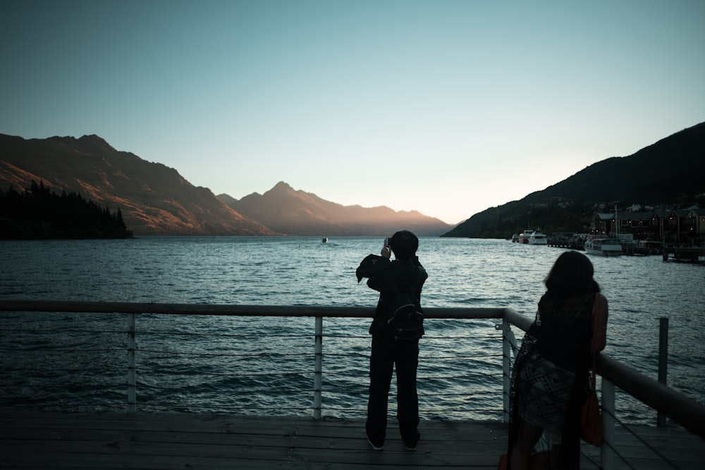 two silhouette of man and woman near balustrade