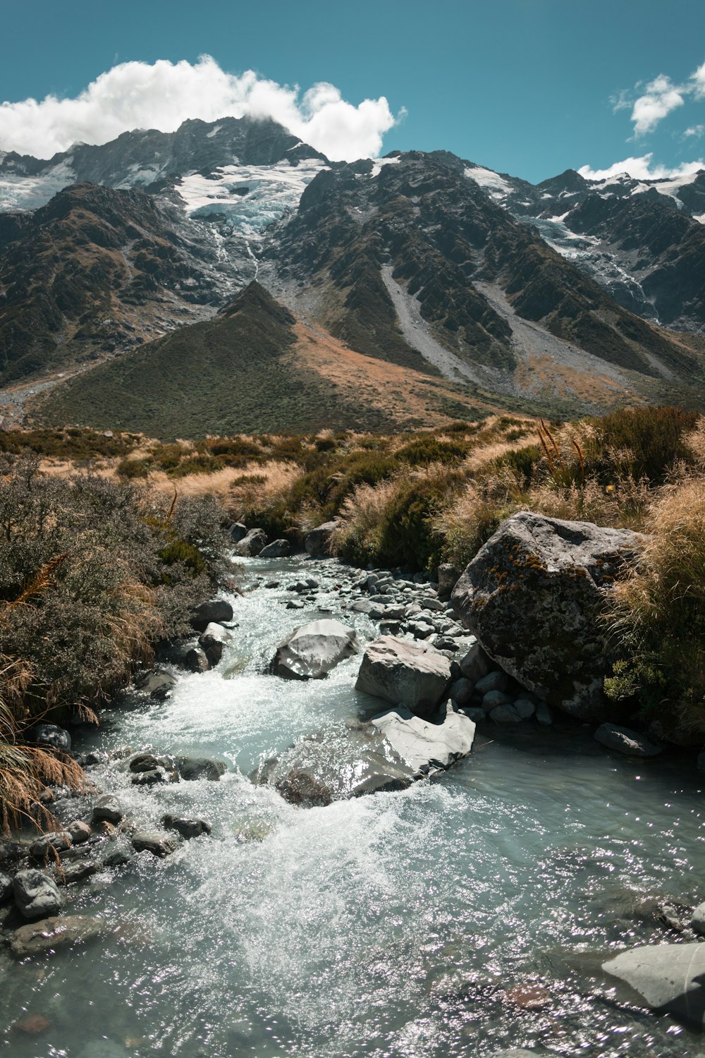 river beside mountain during daytime