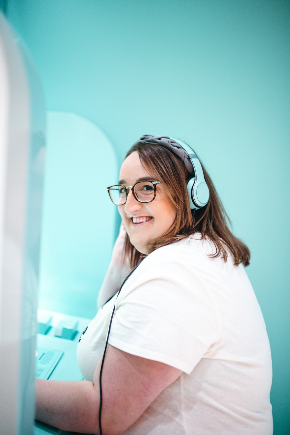 mujer con camiseta blanca con auriculares azules