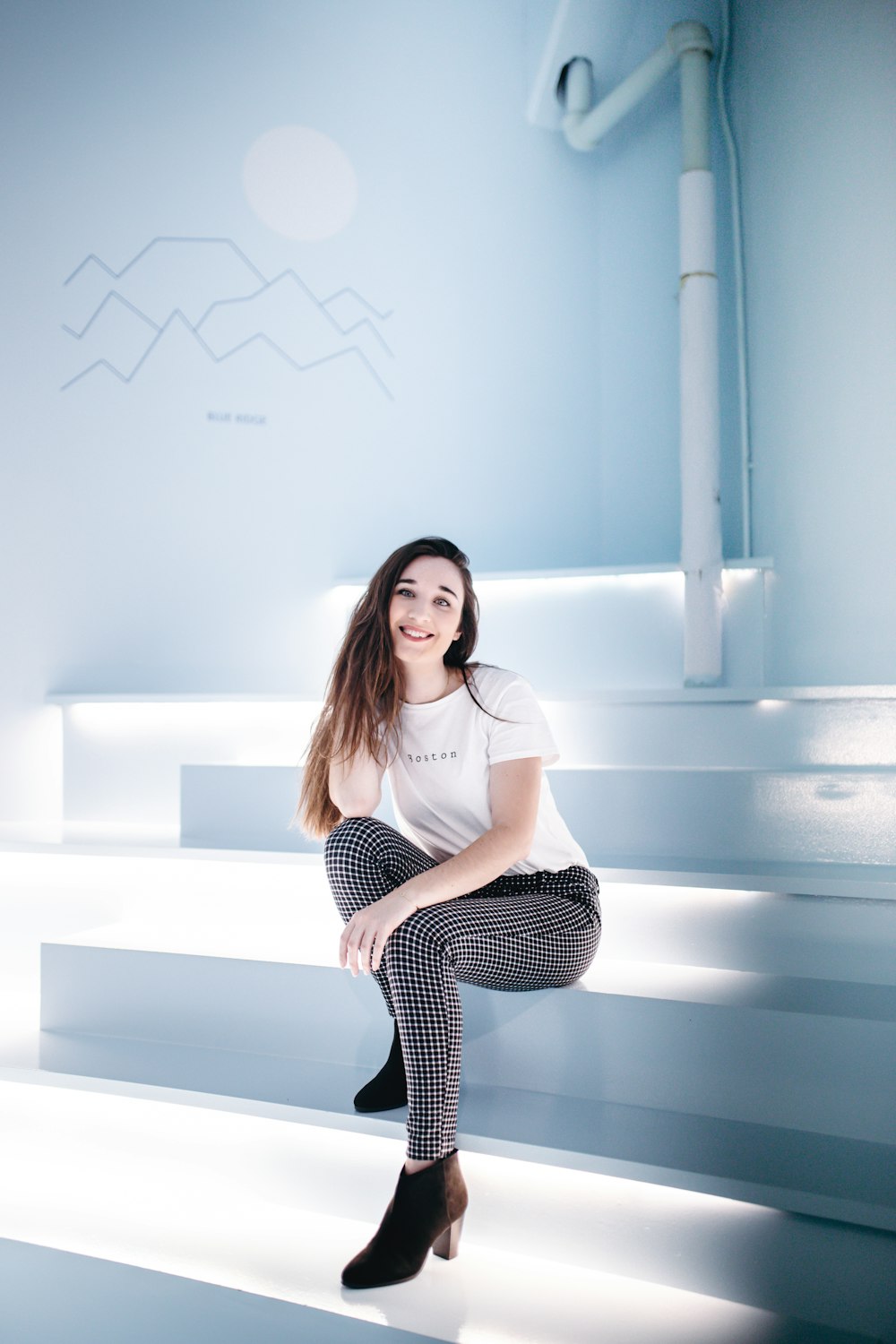 woman in white crew-neck T-shirt sitting on stairs