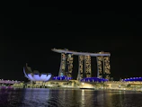 A panoramic view of a modern luxury hotel tower illuminated at night.