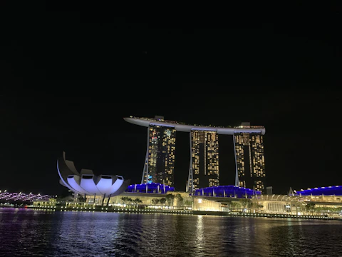 A panoramic view of a modern luxury hotel tower illuminated at night.