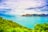 A scenic view of Mayotte's lush green hills meeting the turquoise lagoon waters.