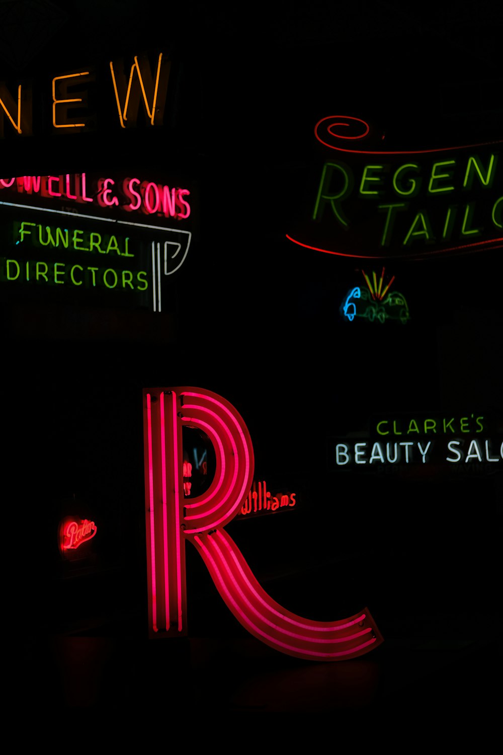 neon signs are lit up in the dark