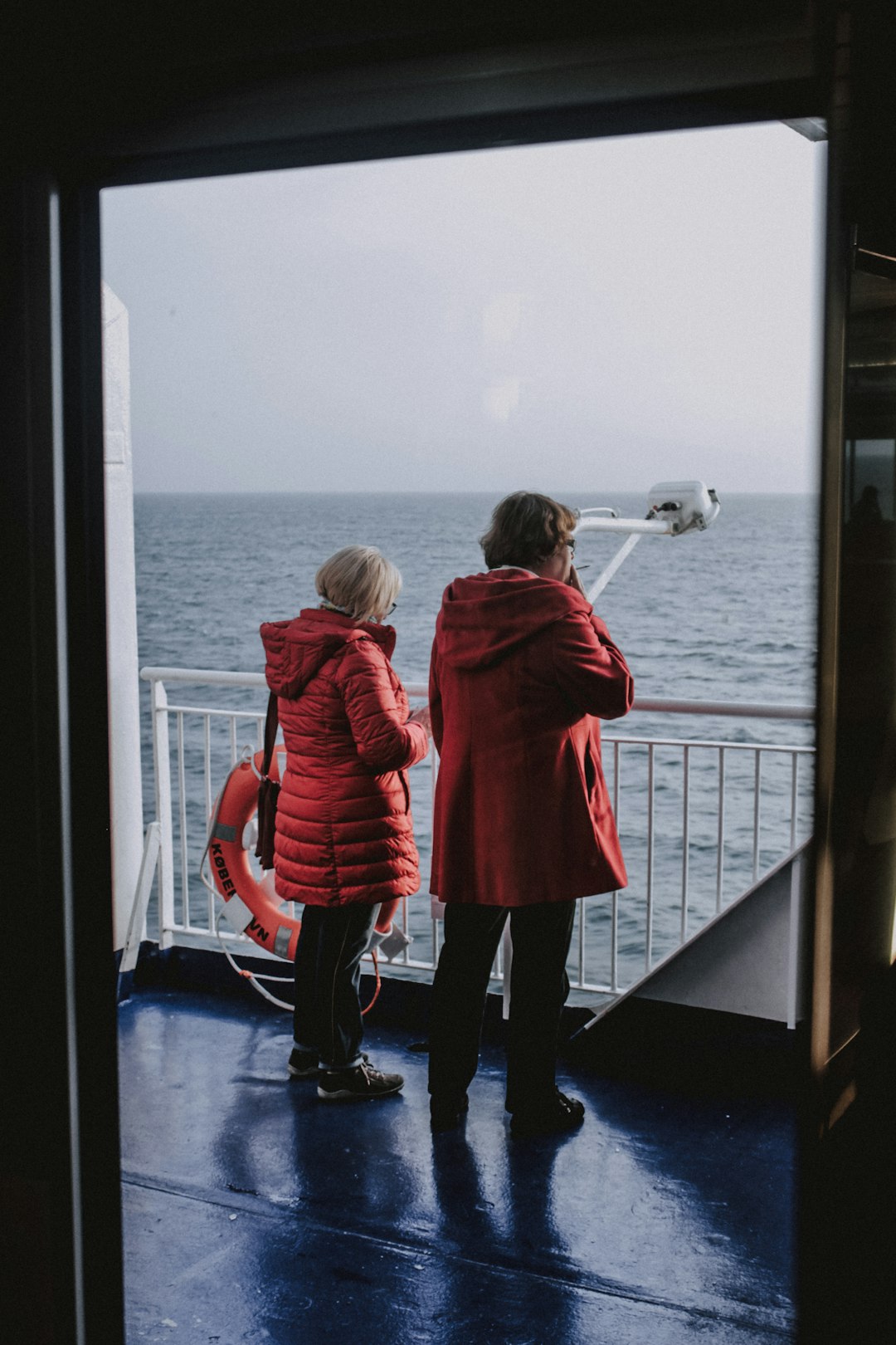 shallow focus photo of two women in red hoodies