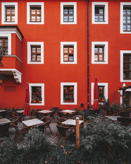 An elegant café terrace with light green and beige tones, inviting for a relaxing moment abroad.