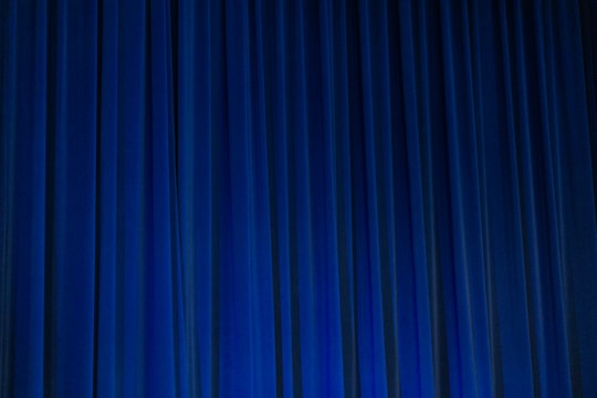 Automated curtains smoothly opening in a contemporary home setting with ambient blue lighting.