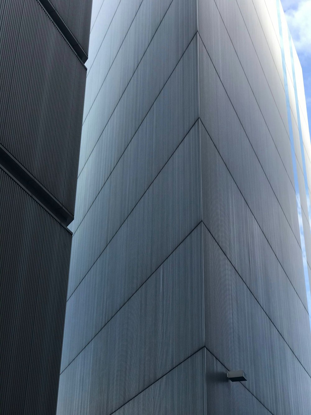 low-angle photography of gray high-rise building under blue and white sky