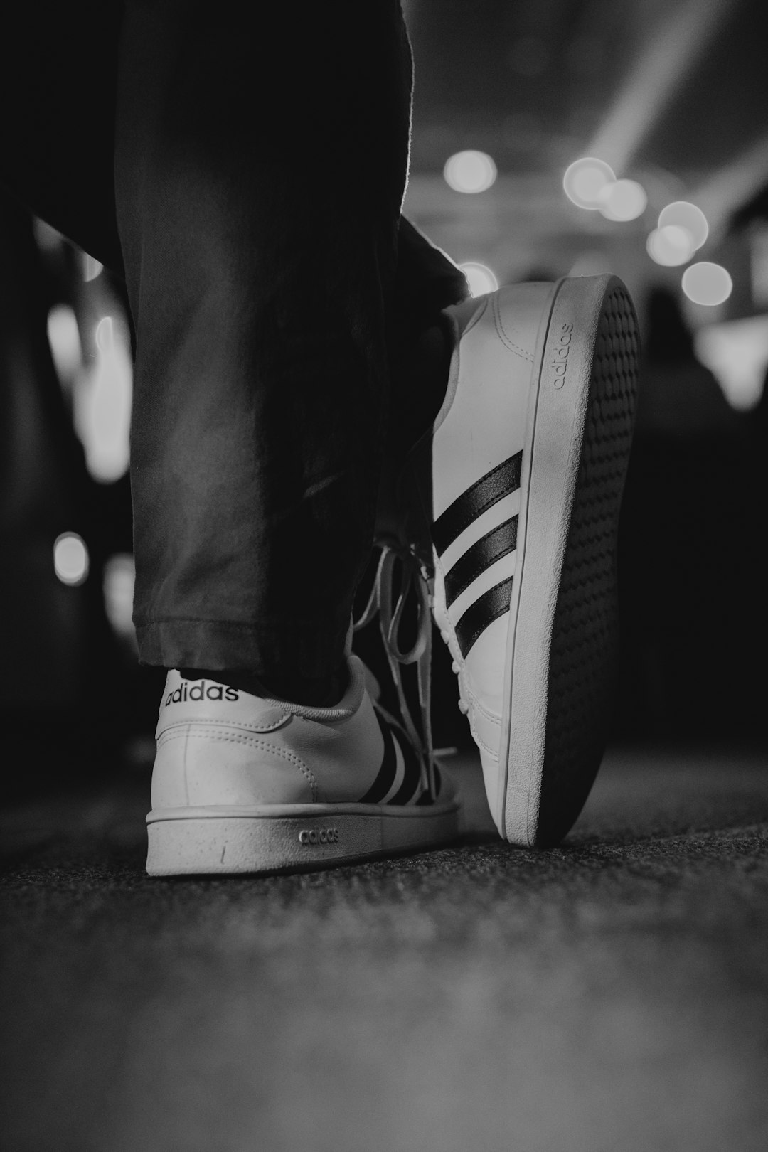 person wearing adidas low-top sneakers