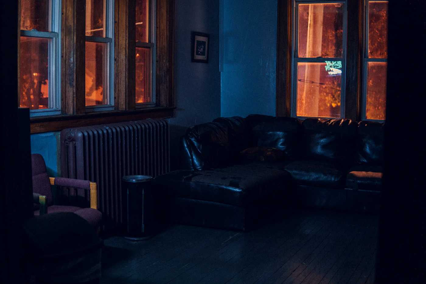 The Evening Apartment — lounge in deep blue tones lit at night (placeholder photograph)