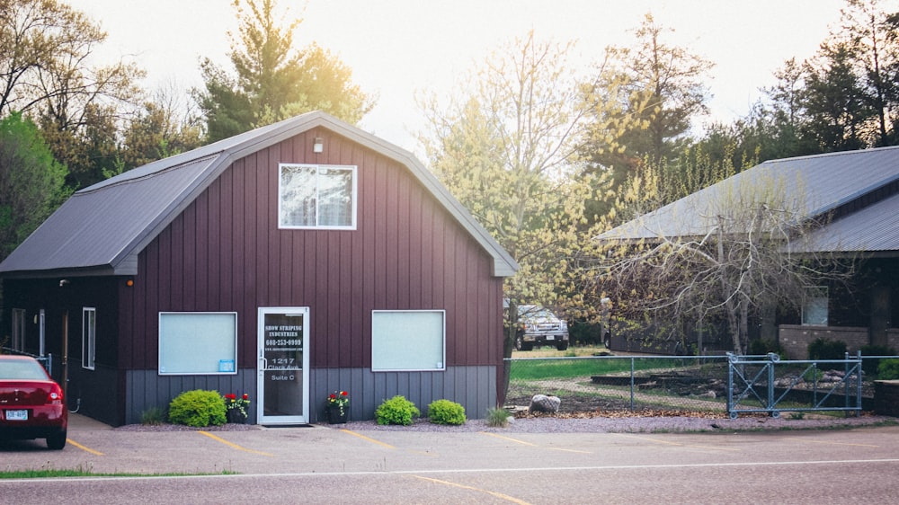 maroon house with red vehicle beside