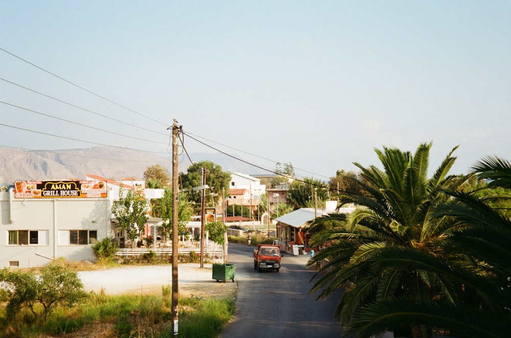 red car beside green trees during daytime