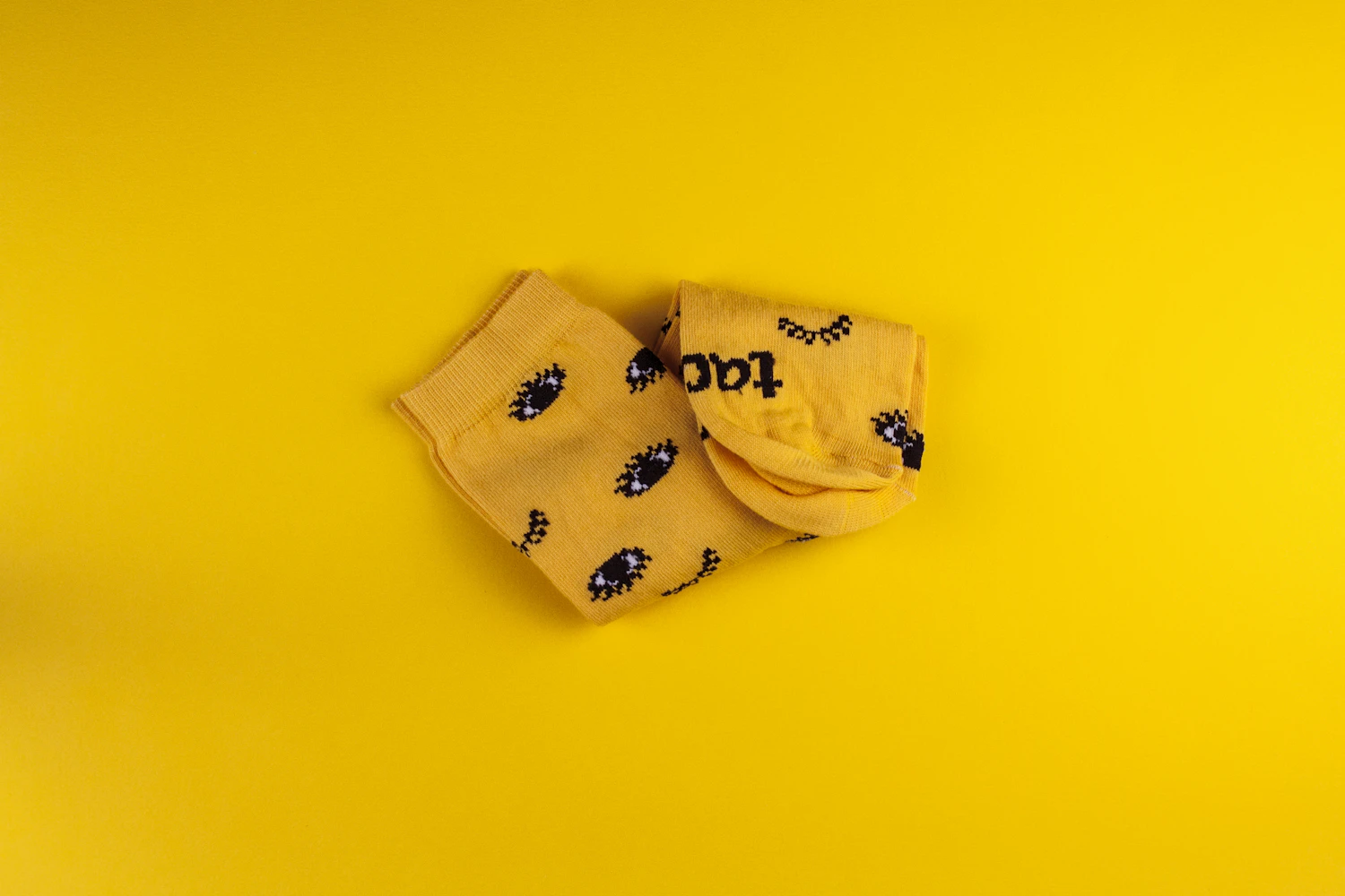 Ribbed crew socks in acid yellow, folded against a yellow ground