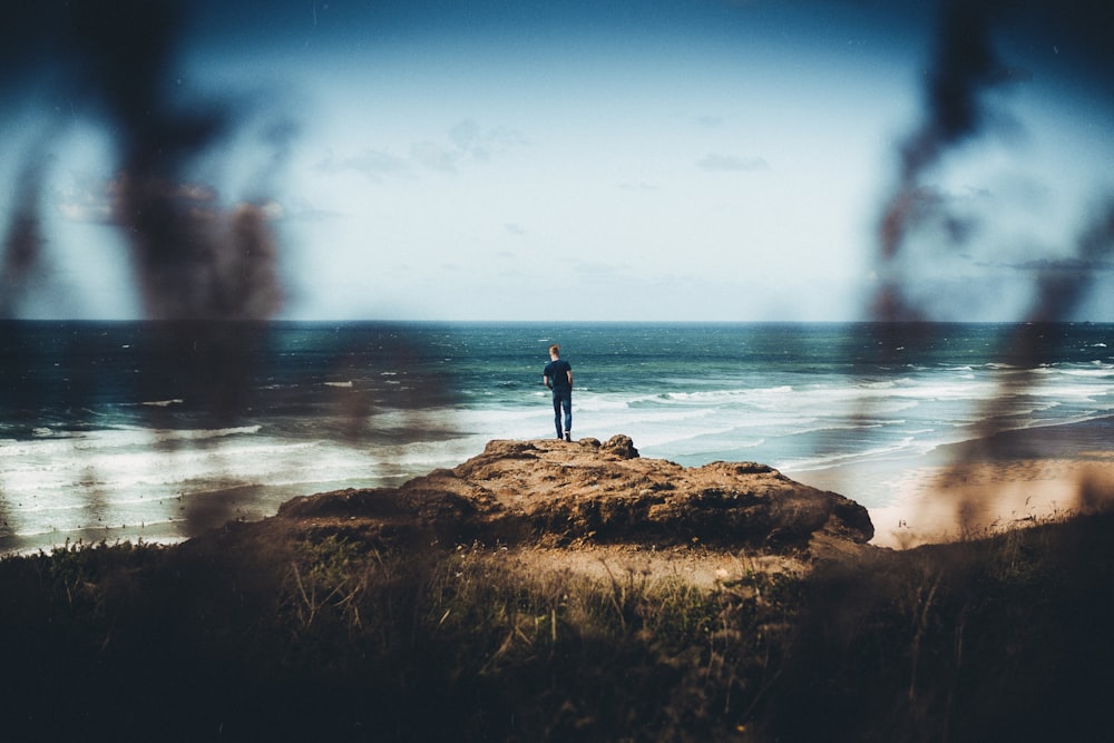 man standing on brown stone during daytime