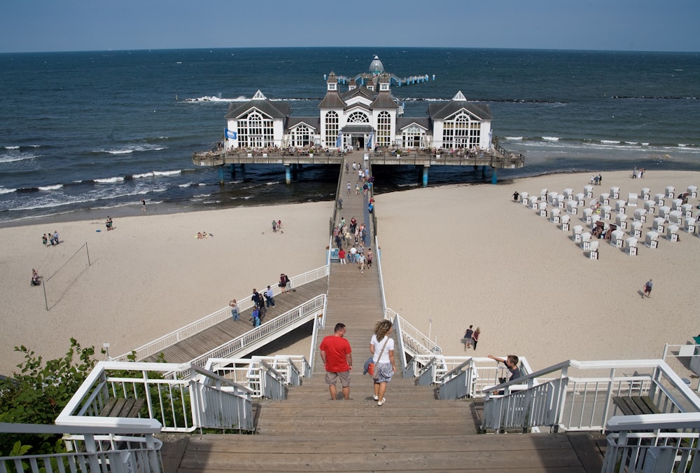 two person walking down stairs on beach