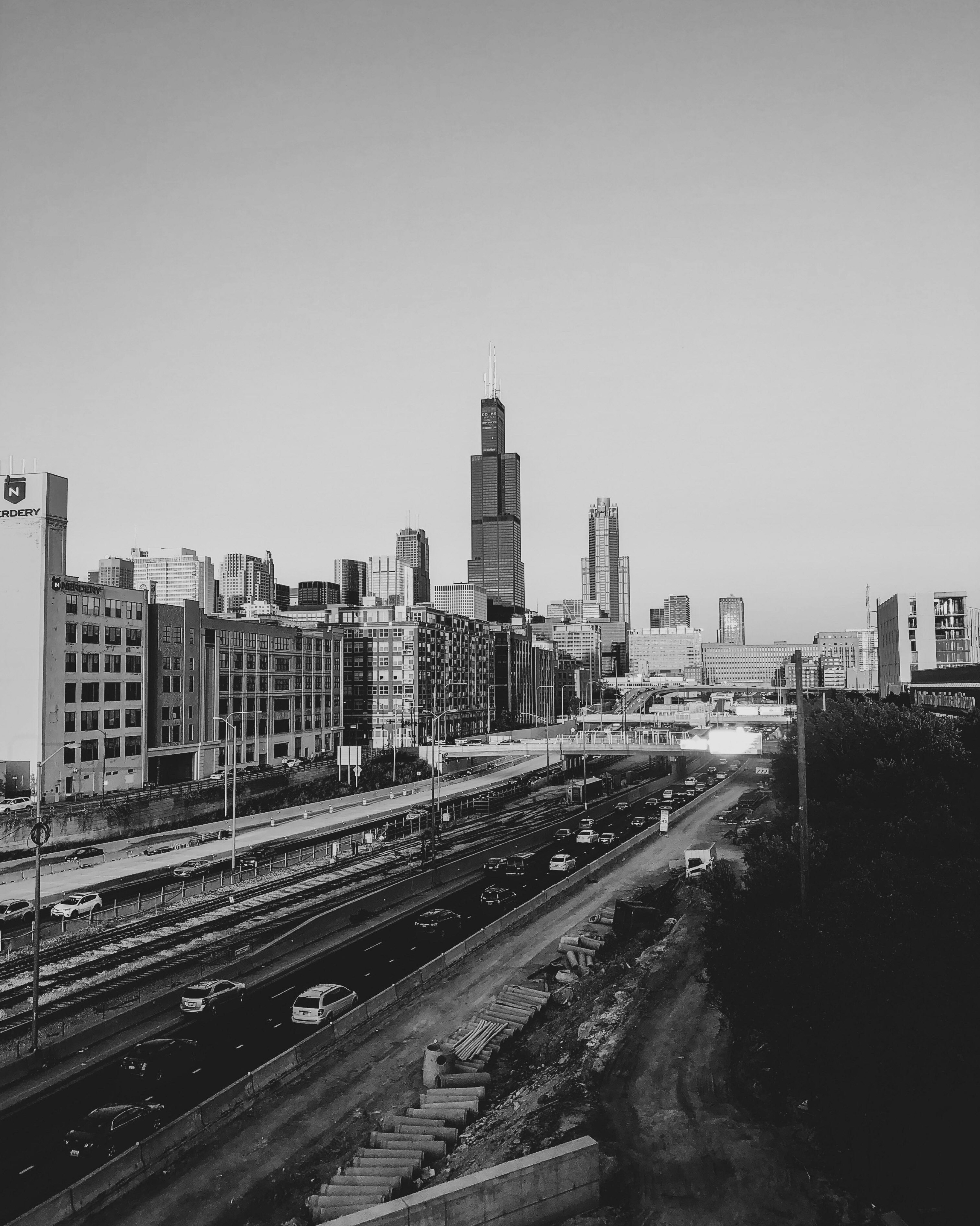 grayscale photo of railroad and buildings