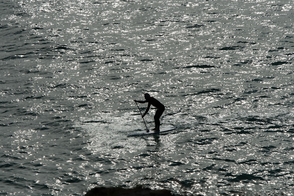 man riding white sailboat on middle ocean