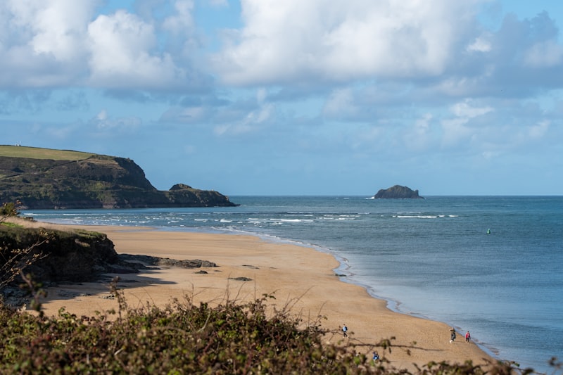 Long Atlantic surf beach below cliffs at Watergate Bay